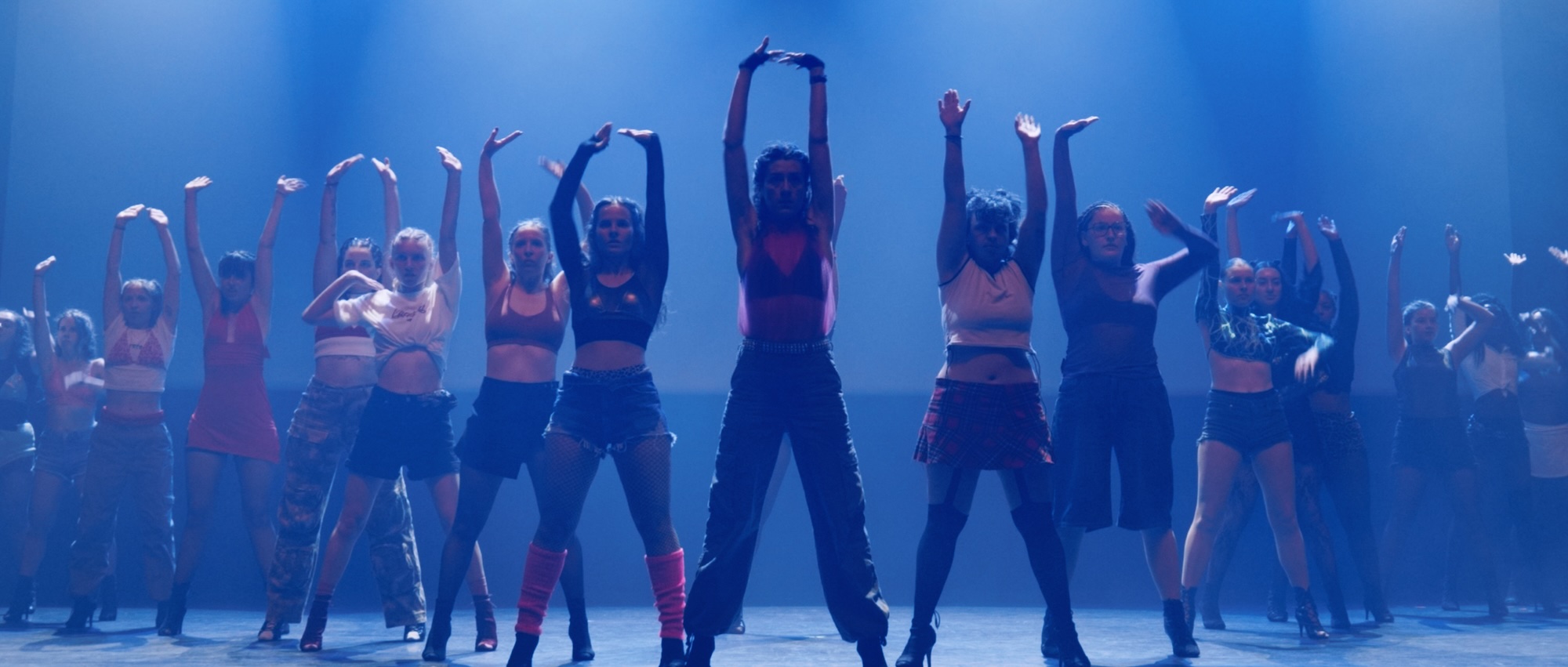 Tableau du spectacle de fin d'année de Diversity Groov'Dance, danseurs bras levés en lumière bleue